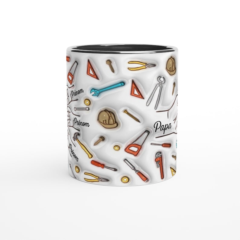 Puede incluir: Una taza de cer&aacute;mica blanca con interior negro, cubierta con un patr&oacute;n repetido de herramientas manuales en varios colores. La taza tiene la palabra "Papa" y la palabra "Pr&eacute;nom" impresa.