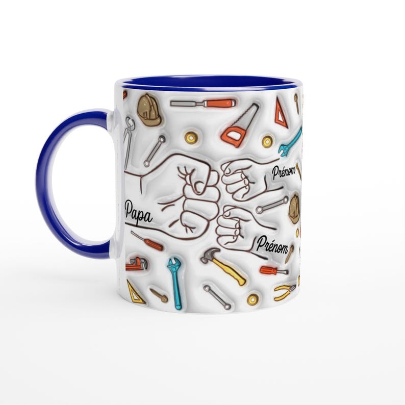 Puede incluir: Taza de cer&aacute;mica blanca con asa y borde azules. La taza presenta un dise&ntilde;o de herramientas y pu&ntilde;os, con las palabras "Papa" y "Pr&eacute;nom" impresas. Un gran regalo para un padre o abuelo.