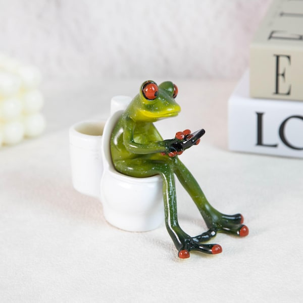 Figura de rana graciosa en el inodoro / Estatua de resina de una rana que envía mensajes de texto