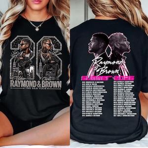 May include: A black t-shirt featuring a graphic of Usher and Chris Brown with the text 'Raymond & Brown The R&B Tour' on the front. The back displays the same artists with the text 'Raymond & Brown Summer 2026' and a list of tour dates and locations.