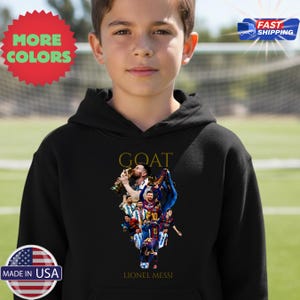 May include: Black hoodie with a graphic of Lionel Messi, with the word "GOAT" above the image. The image features Messi holding a trophy and other images of him in a soccer uniform. The text "LIONEL MESSI" is below the image.