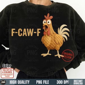 May include: Black sweatshirt featuring a cartoon chicken design. The chicken is brown with a red comb and wattle, and white tail feathers. The text "F-CAW-F" is above the chicken. A red circle with "ORIGINAL DESIGN" is on the bottom right.
