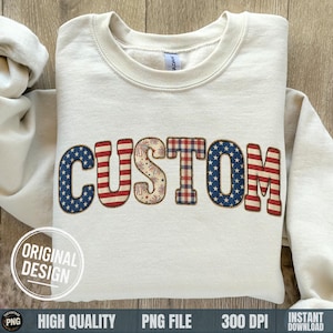 Op de afbeelding: Crèmekleurige sweatshirt met het woord "CUSTOM" in een patriottisch ontwerp. De letters hebben patronen van de Amerikaanse vlag, vuurwerk en ruitjes. De sweatshirt heeft een ronde hals en lange mouwen. De woorden "ORIGINAL DESIGN" staan in een cirkel linksonder.