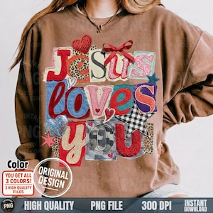 May include: Brown sweatshirt with the phrase "Jesus Loves You" in a patchwork design. The letters are in various colors and patterns, including leopard print, gingham, and camouflage. A red heart and bow accent the design.