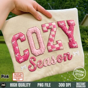 Może przedstawiać: Beżowa tkanina z wyhaftowanymi słowami "COZY Season" w kolorze różowym. Litery mają wzór dzianiny lub kraty, ozdobione małymi białymi kokardkami. Obraz zawiera również tekst "Pink", "Original Design" i "High Quality PNG File".