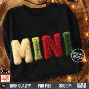 May include: Black sweatshirt with the word "MINI" in a fluffy, textured font. The letters are in cream, green, red, and green. The design includes a "Original Design" badge.