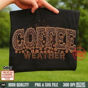 May include: Black t-shirt with the words "COFFEE WEATHER" in a brown, leopard print design. Coffee beans are scattered around the text. The shirt is held up by a hand against a green background.