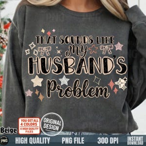 以下が含まれることがあります： 「THAT SOUNDS LIKE MY HUSBAND'S Problem」の文字が様々なフォントと色でプリントされた濃いグレーのスウェットシャツ。星や装飾的な要素も含まれています。下部には「Beige」と書かれたベージュ色の円があります。