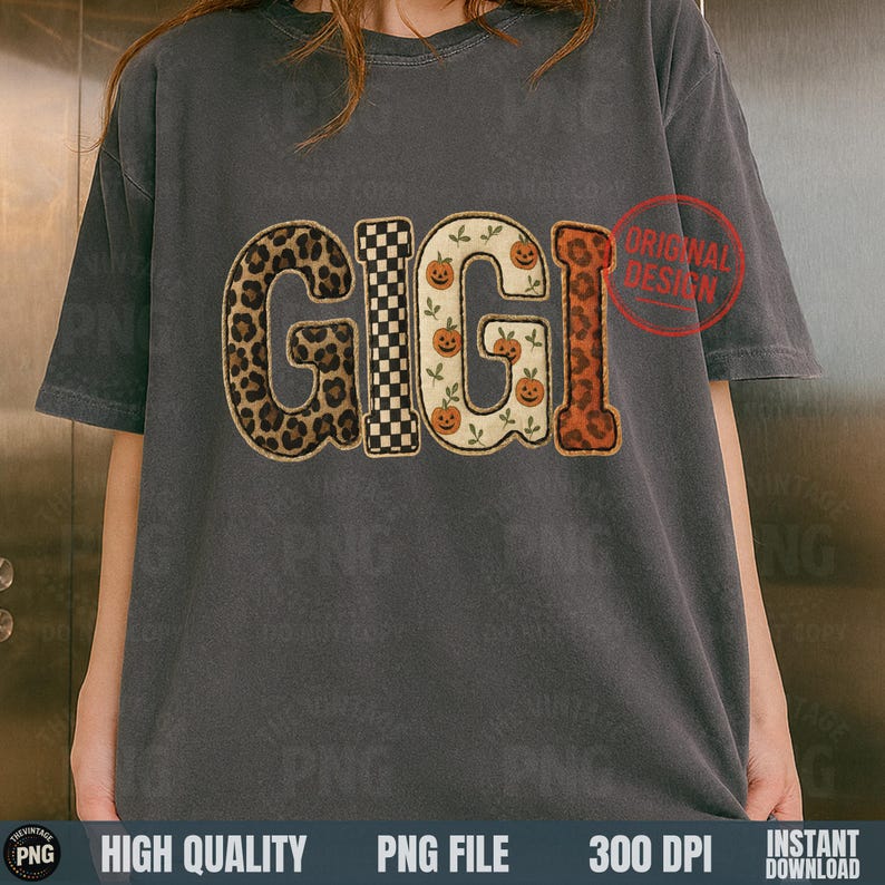 May include: A gray t-shirt with the word "GIGI" in a decorative design. The letters feature a leopard print, a black and white checkerboard pattern, and pumpkins. A red "ORIGINAL DESIGN" stamp is visible.