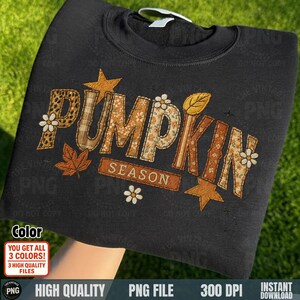 Black sweatshirt folded with “Pumpkin Season” patch embroidery artwork