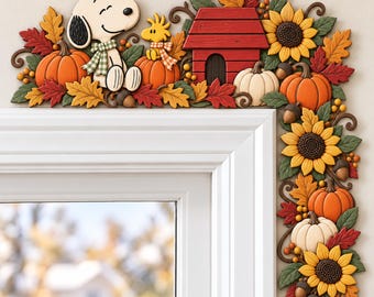 May include: A decorative corner door frame accent featuring Snoopy and Woodstock with a red doghouse, orange and white pumpkins, yellow sunflowers, brown acorns, and multicolored autumn leaves in shades of red, orange, yellow, and green.