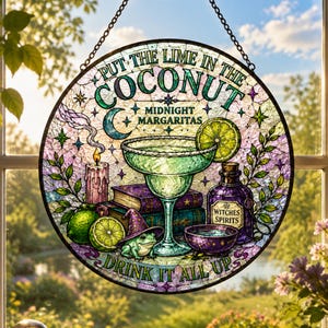 May include: A circular stained glass suncatcher featuring a margarita glass, a lime, a candle, books, a frog wearing a hat, and a bottle labeled Witches Spirits. The text reads Put the lime in the coconut, Midnight Margaritas, and Drink it all up.