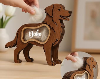 May include: A wooden dog-shaped keepsake box with a rectangular opening containing white fur and the name "Duke". The dog is brown and has a detailed design. A hand is placing more fur into the opening.