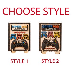 May include: Two rectangular wooden signs labeled STYLE 1 and STYLE 2, each featuring the text GAMER DAD LIKE A NORMAL DAD, ONLY MUCH COOLER. The signs include wooden cutouts of game controllers, red hearts, and name tags for William, Olivia, and Daniel.