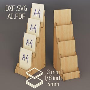 May include: Two light-colored wooden tiered display stands with four slots each. The left stand holds four A4 papers. Text includes .DXF .SVG .AI .PDF, 3 mm, 1/8 inch, and 4 mm. The design features stacked layers for holding documents.