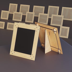 Könnte beinhalten: Holzbilderrahmen in verschiedenen Größen, einige mit schwarzen Einsätzen, andere leer. Die hellen Holzrahmen haben eine sichtbare Maserung und einige sind mit einem Ständer ausgestattet.