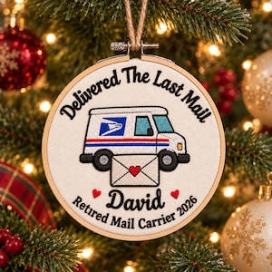 Könnte beinhalten: Ein runder Stickrahmen-Anhänger mit weißem Stoffhintergrund, einem gestickten Postauto, einem weißen Umschlag mit rotem Herz sowie dem schwarzen Text Delivered The Last Mail, David und Retired Mail Carrier 2026.
