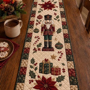 May include: A rectangular quilted table runner featuring a cream-colored center with a nutcracker, poinsettia flowers, wrapped gifts, candy canes, and ornaments. The border consists of a patchwork pattern in shades of red, green, and tan.