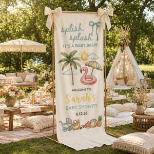 May include: A cream-colored banner with gold frame, decorated with a tropical theme for a baby shower. The banner reads "splish splash! It's a baby bash!" and features a flamingo float, palm tree, and sun illustration.