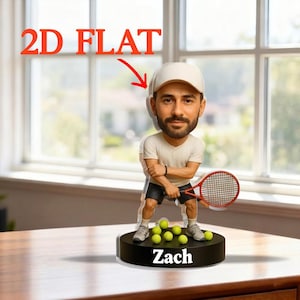 Puede incluir: Figura plana 2D de un tenista con gorra, camisa y pantalones cortos blancos, sosteniendo una raqueta roja. La figura está sobre una base negra con el nombre "Zach" y pelotas de tenis amarillas. El texto "2D FLAT" es rojo.