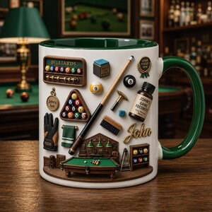 May include: A white ceramic mug with a green handle and rim, decorated with 3D billiard-themed elements. Features a miniature pool table, cue stick, billiard balls, and the text "John's Game Recovery". A unique gift for pool players.