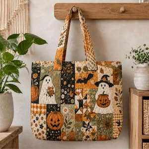Può includere: Una borsa tote trapuntata con un design patchwork caratterizzato da motivi di Halloween, tra cui fantasmi bianchi, zucche di Halloween arancioni, pipistrelli neri e motivi floreali nei toni dell'arancione, verde, nero e crema.