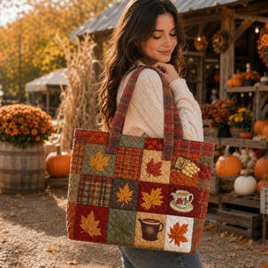 Può includere: Una borsa tote trapuntata con un design patchwork di quadrati a tema autunnale. Il tessuto presenta motivi di foglie d'acero rosse, arancioni e verdi, texture scozzesi, una teiera bianca con accenti floreali e una tazza marrone con bevanda.