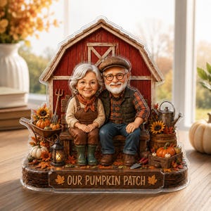 Könnte beinhalten: Ein dekorativer Acrylaufsteller mit einem älteren Paar, das auf einer Bank vor einer roten Scheune sitzt. Der Sockel trägt die Aufschrift "OUR PUMPKIN PATCH" und ist mit Miniaturkürbissen, Sonnenblumen, einer Laterne und Gartengeräten verziert.
