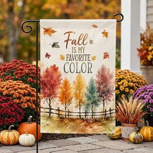 Peut inclure: Un drapeau de jardin rectangulaire avec le texte Fall IS MY FAVORITE COLOR en lettres marron et vertes. Le motif comprend une illustration à l'aquarelle d'une clôture en bois, cinq arbres aux couleurs automnales et des feuilles tombantes.