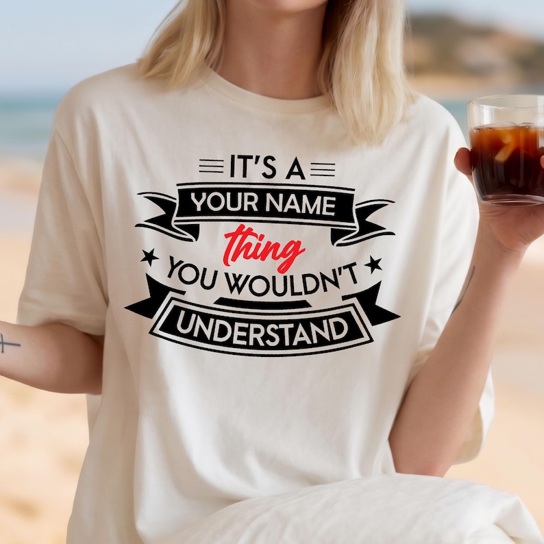May include: A cream-colored short-sleeve t-shirt featuring black and red text that reads IT'S A YOUR NAME thing YOU WOULDN'T UNDERSTAND. The design includes black banners, stars, and horizontal lines surrounding the bold, centered lettering.