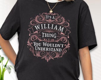 May include: Black t-shirt with a decorative pink and white design. The design includes the text "IT'S A WILLIAM THING YOU WOULDN'T UNDERSTAND" in a decorative font. The shirt has a crew neck and short sleeves.