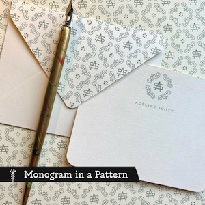 May include: Stationery set featuring a monogram design. The set includes a pen, envelopes, and notecards. The notecards and envelopes have a repeating pattern. The pen is gold and brown. The text "Adeline Scott" is printed on the notecard.