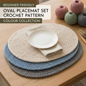 Op de afbeelding: Een set van drie ovale gehaakte placemats in beige, blauw en grijs, met een wit bord en een linnen servet. De afbeelding bevat tekst die luidt "BEGINNER FRIENDLY OVAL PLACEMAT SET CROCHET PATTERN COLOUR COLLECTION". Haakkatoen bollen en haaknaalden zijn op de achtergrond.