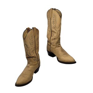 May include: A pair of tan cowboy boots with decorative stitching and black soles. The boots have a pointed toe and a tall shaft, typical of Western wear. The leather appears worn, suggesting a vintage or well-loved item.