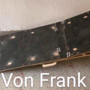 Peut inclure: Une rampe en bois avec une surface noire, avec le texte "Von Frank". La rampe est construite avec plusieurs sections et poss&egrave;de une poign&eacute;e. Elle est con&ccedil;ue avec une l&eacute;g&egrave;re courbe et est sur&eacute;lev&eacute;e &agrave; une extr&eacute;mit&eacute;.