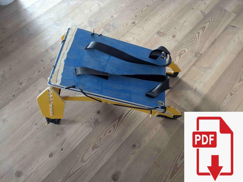 May include: A handmade wooden sled with a blue top and yellow frame. The sled has black straps and is designed for recreational use. The sled's dimensions are approximately 30 inches long and 15 inches wide.