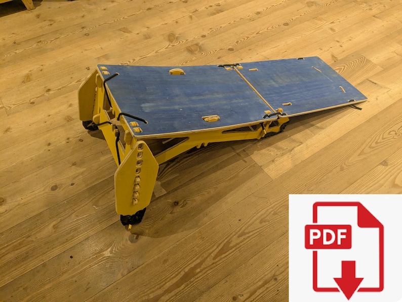 May include: A wooden folding table with a blue tabletop and yellow frame. The table is partially folded, revealing its hinges and support structure. The image includes a PDF icon in the lower right corner.
