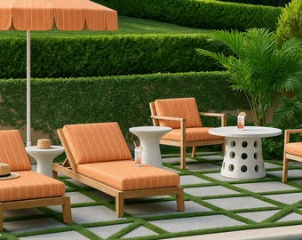 Op de afbeelding: Een terrasmeubelset met oranje-witte gestreepte kussens op houten ligstoelen en een stoel, gecombineerd met witte bijzettafels en een ronde witte tafel met ronde uitsparingen, alles onder een oranje-witte gestreepte parasol.