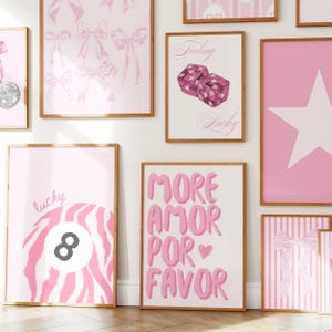 Puede incluir: Una pared de galer&iacute;a con m&uacute;ltiples l&aacute;minas enmarcadas en una paleta de colores rosa. Los dise&ntilde;os incluyen lazos rosas, dados con el texto Feeling Lucky, una estrella blanca, una bola ocho con rayas rosas y la palabra lucky, y el texto MORE AMOR POR FAVOR.