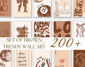 May include: A collection of wall art prints featuring brown and beige tones. Designs include cherries, bows, billiard balls, the New York City skyline, disco balls, cowboy boots, playing cards, and various typography like Born to Shine and Love.