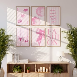 Puede incluir: Un conjunto de seis l&aacute;minas decorativas enmarcadas en tonos rosa y blanco. Los dise&ntilde;os incluyen motivos de cartas de juego, bolas de discoteca, el texto 'slow down you're doing fine', ropa en un tendedero, un lazo y la palabra 'FASHION'.
