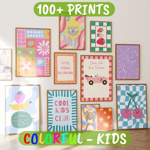 May include: A collection of rectangular wall art prints featuring various colourful illustrations including a cat in a lemon, strawberries, a pink car with the text Drive Into Your Dreams, a smiley face pattern, and the text Cool Kids Club.