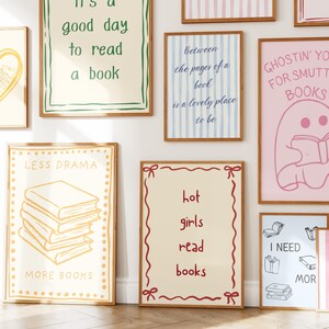 May include: A collection of framed art prints with various book-themed quotes and illustrations. The prints feature phrases like "It's a good day to read a book" and "Hot girls read books." The color palette includes shades of pink, blue, and beige.
