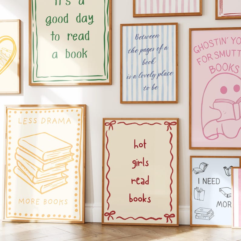 May include: A collection of framed art prints with various book-themed quotes and illustrations. The prints feature phrases like "It's a good day to read a book" and "Hot girls read books." The color palette includes shades of pink, blue, and beige.