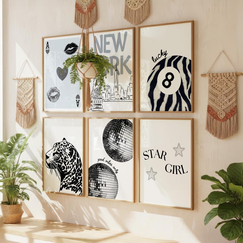 Pu&ograve; includere: Una collezione di stampe artistiche incorniciate con una variet&agrave; di disegni, tra cui uno skyline di New York City, un leopardo, una palla da discoteca e le parole "Star Girl". Le stampe sono in tonalit&agrave; neutre e sono esposte su una parete con decorazioni murali in macram&egrave;.