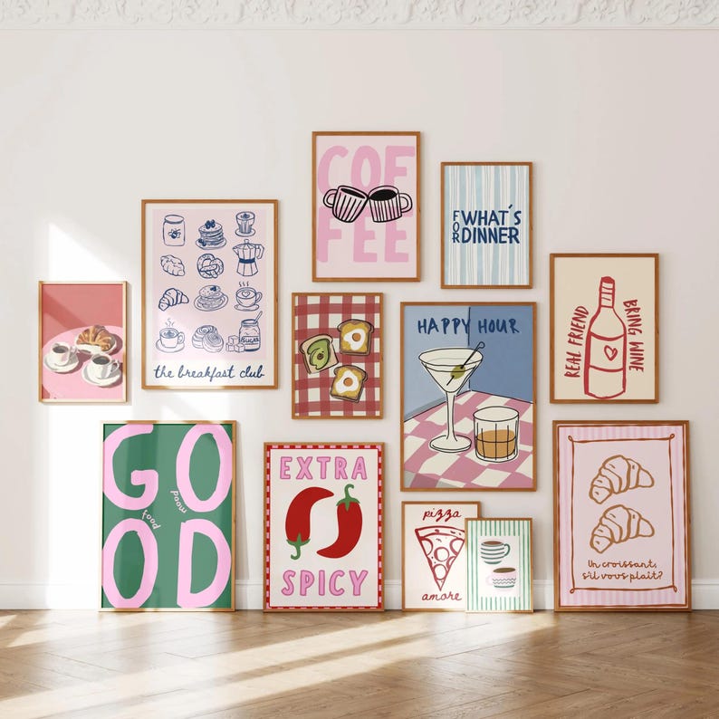 May include: A selection of framed art prints with food and drink themes. Prints feature coffee cups, breakfast items, cocktails, pizza, and phrases like "Happy Hour" and "Extra Spicy." The colour palette includes pink, green, and brown.