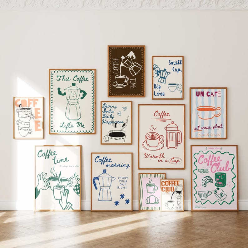 May include: A collection of framed coffee-themed art prints. The prints feature illustrations of coffee makers, cups, and phrases like "Coffee Time" and "Coffee Club." The color palette includes brown, blue, and pink tones.