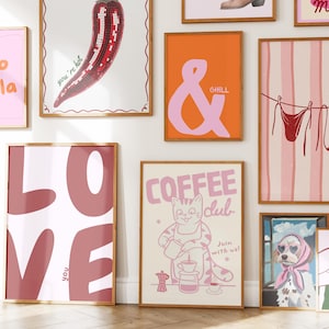 May include: Collection of framed art prints with various designs. Includes a red chili pepper mosaic, an ampersand with "CHILL", a "COFFEE CLUB" cat illustration, and a "LOVE" print. The prints have a retro, whimsical style.