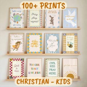 May include: A display of framed Christian-themed art prints for kids. The prints feature colorful illustrations and inspirational messages like "Pray, play, repeat!" and "God is love." The words "100+ PRINTS" and "CHRISTIAN - KIDS" are also visible.