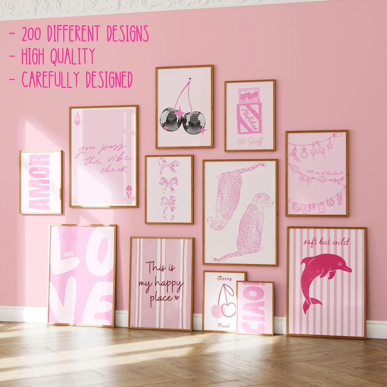 May include: A collection of eleven framed wall art prints featuring various pink-themed graphic designs, including disco cherries, a leopard, a dolphin, and text-based art, displayed on a solid pink wall with text overlays at the top left.
